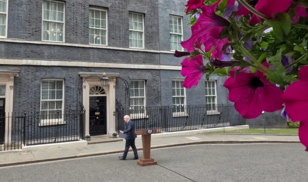 보리스 존슨 영국 총리가 7일(현지 시각) 총리 관저 앞에서 사임 발표를 하고 돌아서고 있다. (사진출처=영국 가디언)